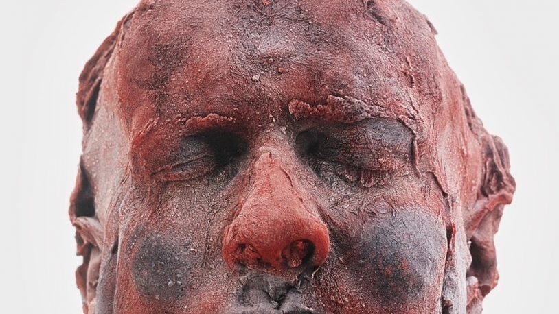 A sculpture of a man's head with closed eyes