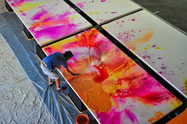 Man painting bending over a painting