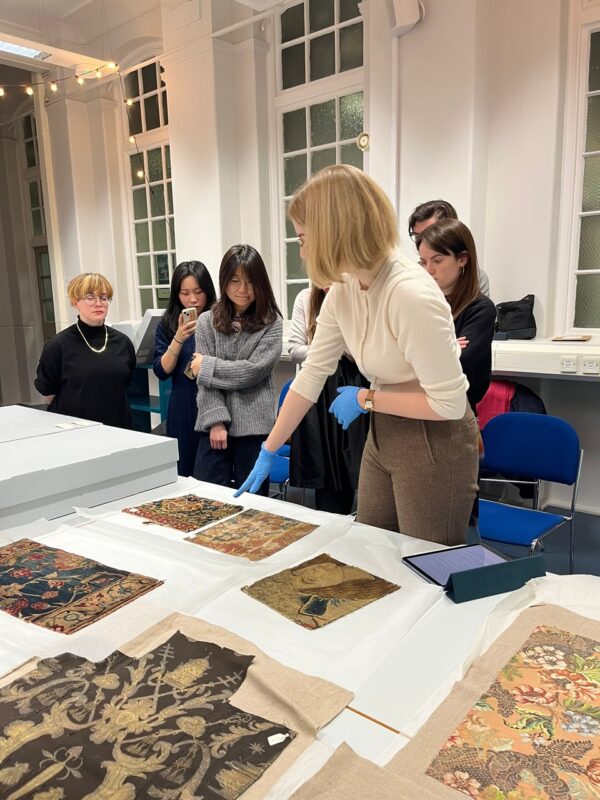Students and staff looking at materials as part of the Textile Working Group