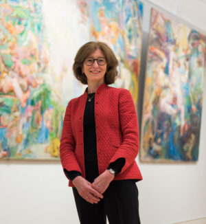 Deborah Swallow in front of colourful paintings