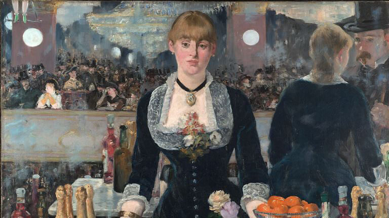 A woman standing behind a bar facing straight ahead.