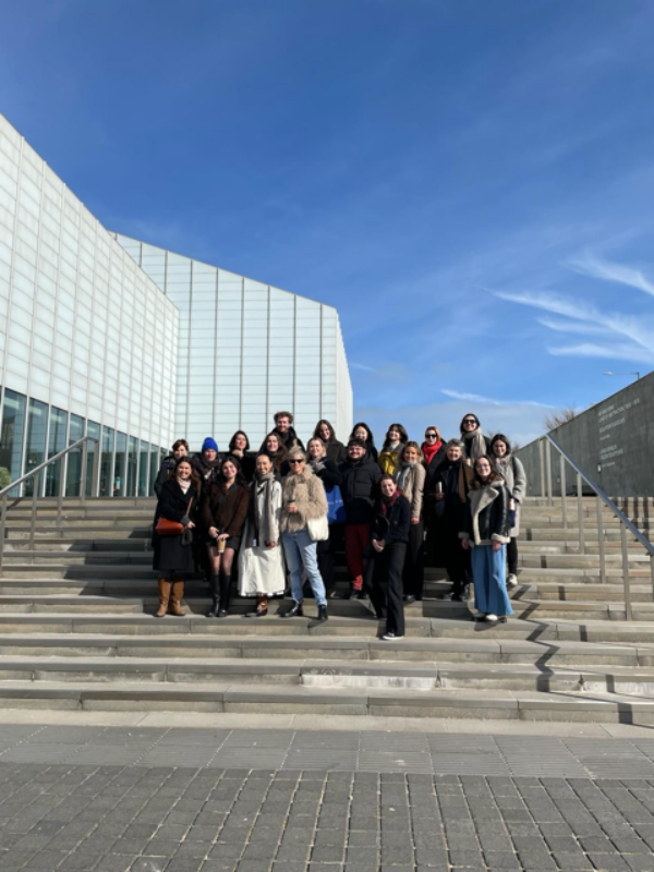 a student group stood on a large outdoor stairway for a group photo
